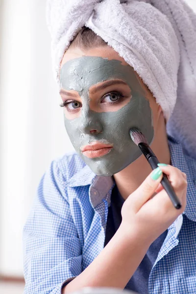 Γυναίκα εφαρμογή πηλό μάσκα με βούρτσα στο σπίτι — Φωτογραφία Αρχείου