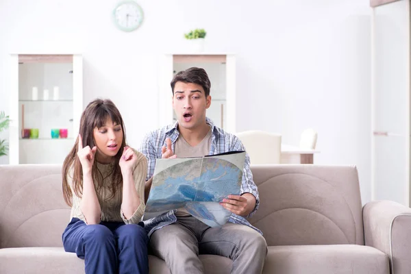 Young family discussing travel plans with map