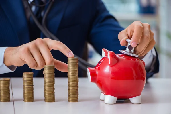 Businessman with stacks of coins in the office — Stock Photo, Image