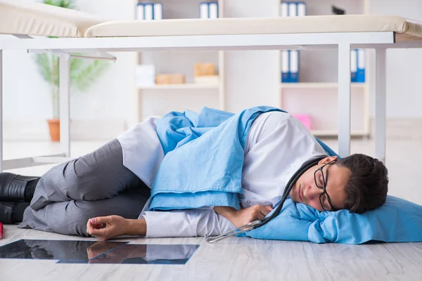 Arzt schläft nach langer Nachtschicht auf dem Boden — Stockfoto