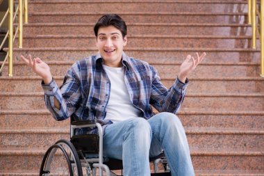 Tekerlekli sandalyedeki engelli adam merdivenlerde sorun yaşıyor.