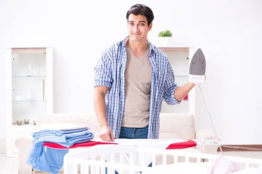 Genç baba yeni doğan bebeğe bakıyor.