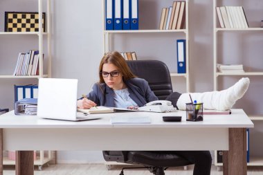 Ofiste bacağı kırık, meşgul bir çalışan.