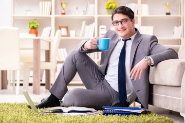 İş adamı evde yerde çalışıyor.