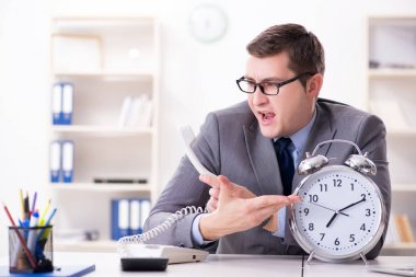Acil ve son teslim tarihi konseptinde alarm veren bir işadamı. 