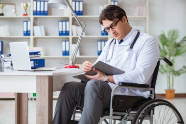 Hastanede çalışan tekerlekli sandalyedeki engelli doktor.