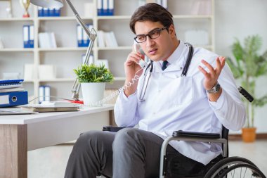 Hastanede çalışan tekerlekli sandalyedeki engelli doktor.