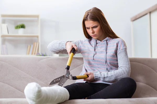 Mladá žena se zlomenou nohou doma — Stock fotografie