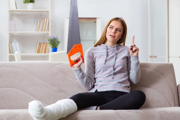 Jeune femme avec jambe cassée à la maison — Photo