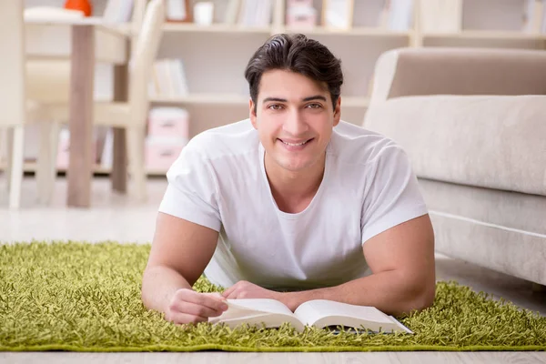 Ο άνθρωπος διαβάζει βιβλίο στο σπίτι στο πάτωμα — Φωτογραφία Αρχείου