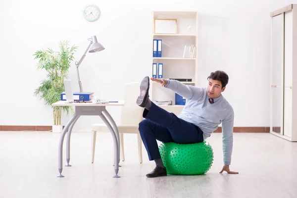 Werknemer traint met Zwitserse bal tijdens de lunchpauze — Stockfoto