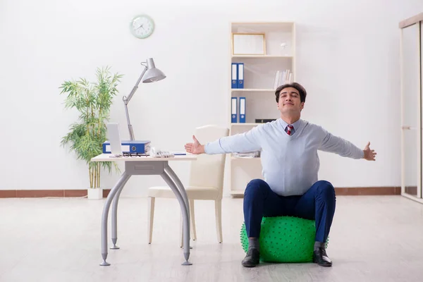 Werknemer traint met Zwitserse bal tijdens de lunchpauze — Stockfoto