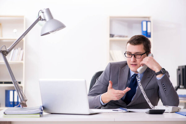 Businessman employee talking on the office phone