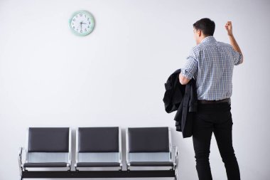 Adam sabırsızlıkla lobide bekliyor.