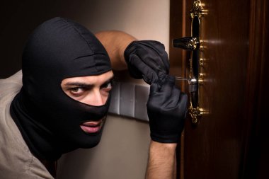 Suç mahallinde kar maskesi takan bir hırsız.