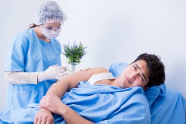 Doktor hastane odasında tıbbi enjeksiyon yapıyor.