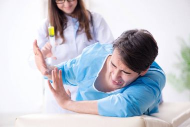 Komik adam şırınga iğnesine hazırlanıyor.