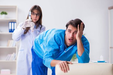 Komik adam şırınga iğnesine hazırlanıyor.