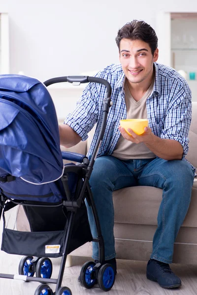 Young father looking after newborn baby at home