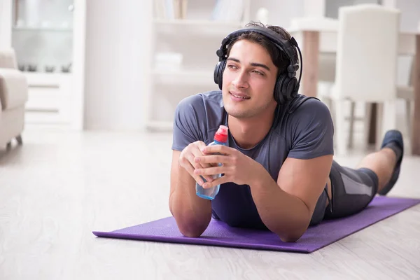 Man die thuis sport doet en naar muziek luistert — Stockfoto