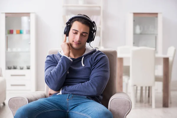 Genç adam evde müzik dinliyor. — Stok fotoğraf