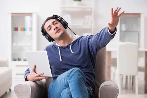 Jonge knappe man die naar muziek luistert met koptelefoon — Stockfoto