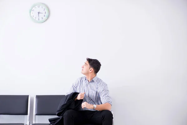 Een man die ongeduldig wacht in de lobby. — Stockfoto