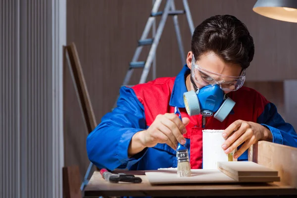 Jeune homme collant des pièces de bois ensemble dans le concept de bricolage — Photo