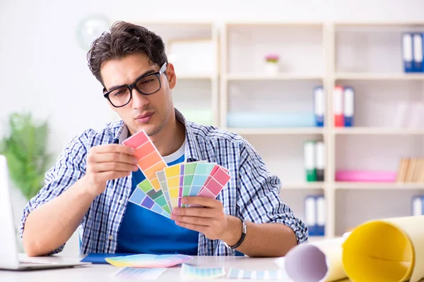 Joven diseñador trabajando en un nuevo proyecto y eligiendo colores — Foto de Stock