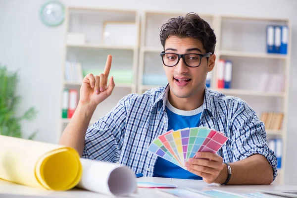 Joven diseñador trabajando en un nuevo proyecto y eligiendo colores — Foto de Stock