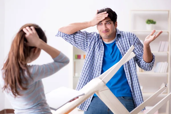 Wife helping husband to repair broken chair at home — Stock Photo, Image