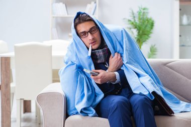 Çalışan işadamı grip olmuşken televizyon izliyor.