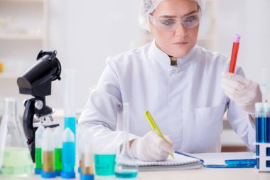 Kadın doktor laboratuvarda kan örneklerini kontrol ediyor.