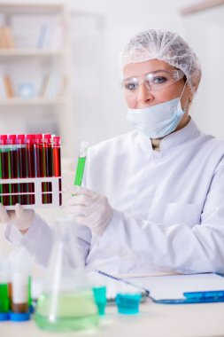 Kadın doktor laboratuvarda kan örneklerini kontrol ediyor.