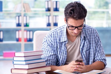 Öğrenci kitap okuyor ve kütüphanede sınavlara hazırlanıyor