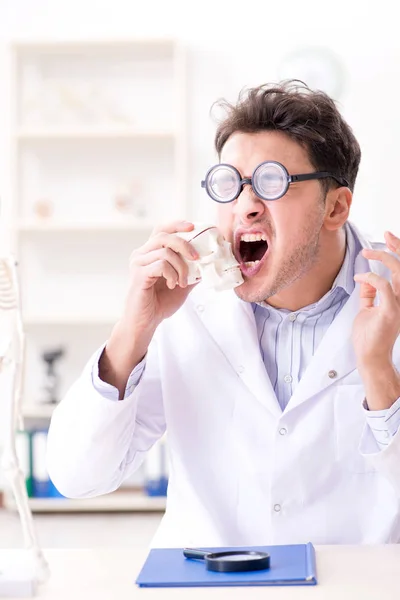 Gekke dokter die menselijk skelet bestudeert — Stockfoto