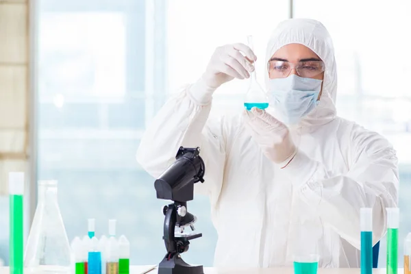 Jovem estudante de química que trabalha em laboratório em produtos químicos — Fotografia de Stock