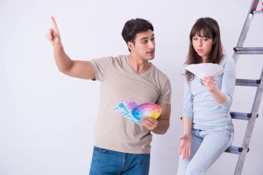 Genç bir aile evlerinde tadilat yapıyor. Duvarları boyuyor.