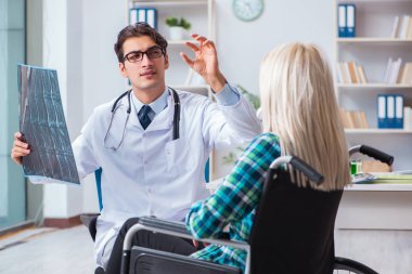 Tekerlekli sandalyedeki engelli kadın erkek doktoru ziyaret ediyor.