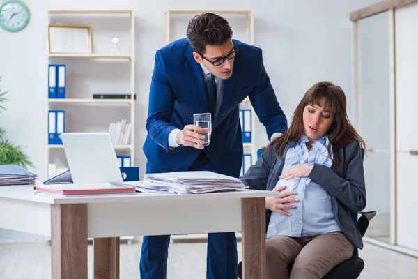 Embarazada mujer luchando en la oficina y conseguir colega él — Foto de Stock