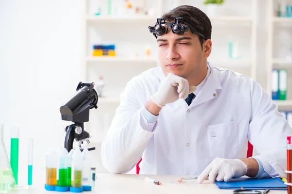 Молодой химик работает в лаборатории — стоковое фото