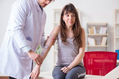 Doktor hastaların eklem esnekliğini kontrol ediyor