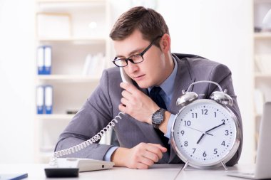 Acil ve son teslim tarihi konseptinde alarm veren bir işadamı. 