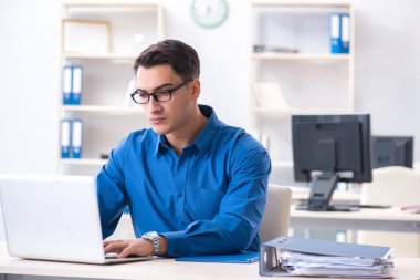 Ofisteki masasında oturan yakışıklı bir işadamı.