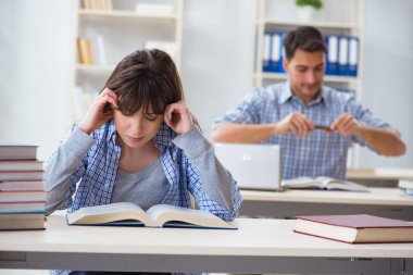 Sınıfta oturan ve okuyan öğrenciler