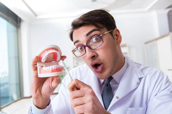 Funny dentist with toothbrush in medical concept