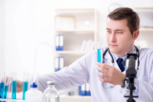 Männlicher Arzt schaut sich Laborergebnisse im Krankenhaus an — Stockfoto