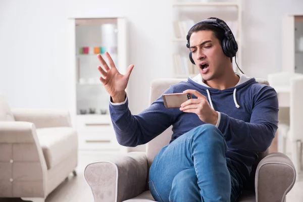 Νεαρός όμορφος άντρας ακούει μουσική με ακουστικά — Φωτογραφία Αρχείου