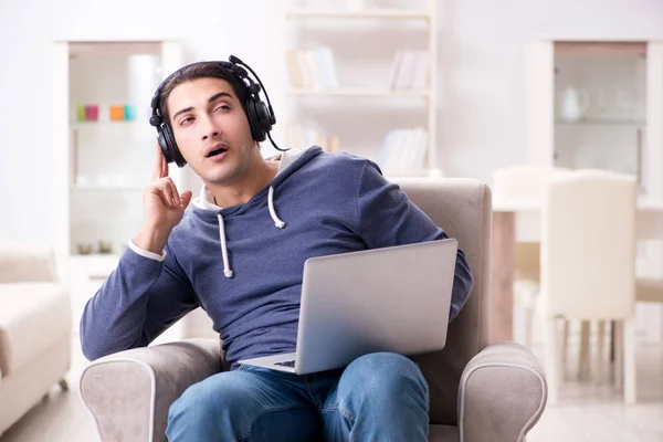 Jonge knappe man die naar muziek luistert met koptelefoon — Stockfoto