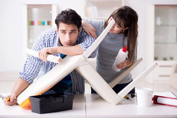 Wife helping husband to repair broken chair at home